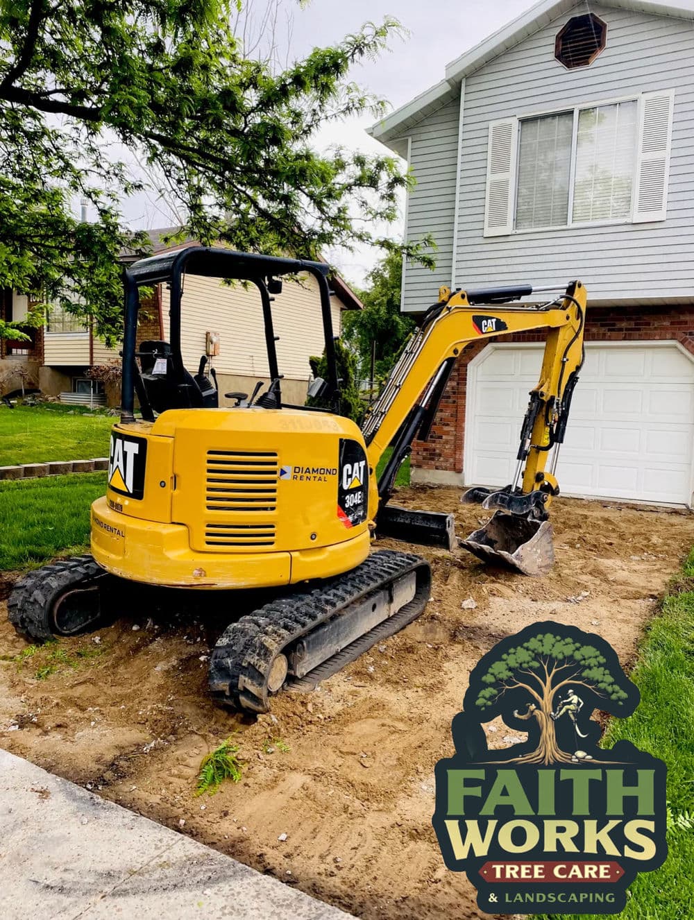 Excavator by Faith Works Tree Care and Landscaping parked in residential yard for project.