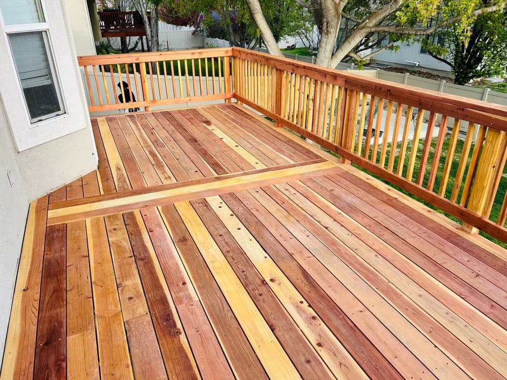 Newly constructed wooden deck with cedar and pine planks, featuring a spacious design.